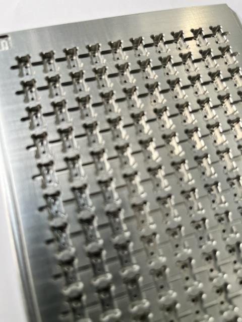 Precision machined stainless steel parts held in a Unitech Shyre cleaning fixture